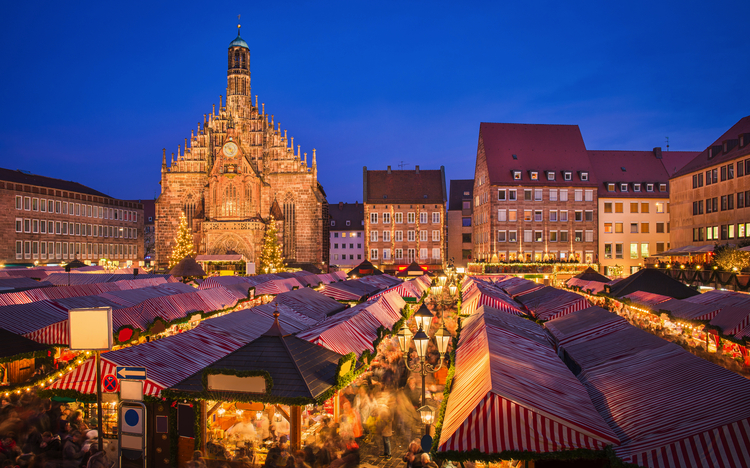 Weihnachtsmarkt mit Kirche bei Abenddämmerung in Nürnberg